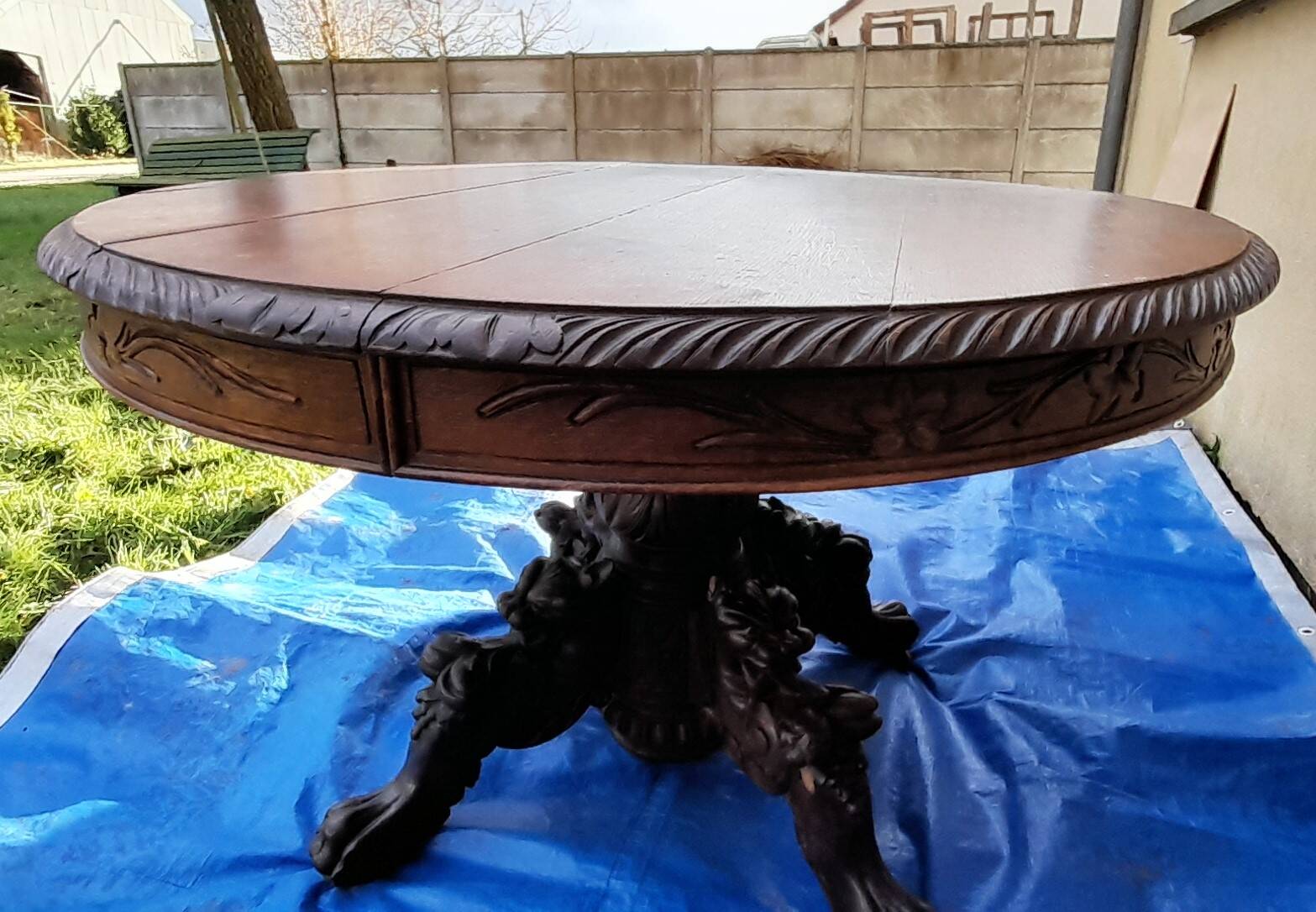 Round table in molded and carved oak with quill decoration, central shaft with 4 runners