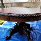Round table in molded and carved oak with quill decoration, central shaft with 4 runners