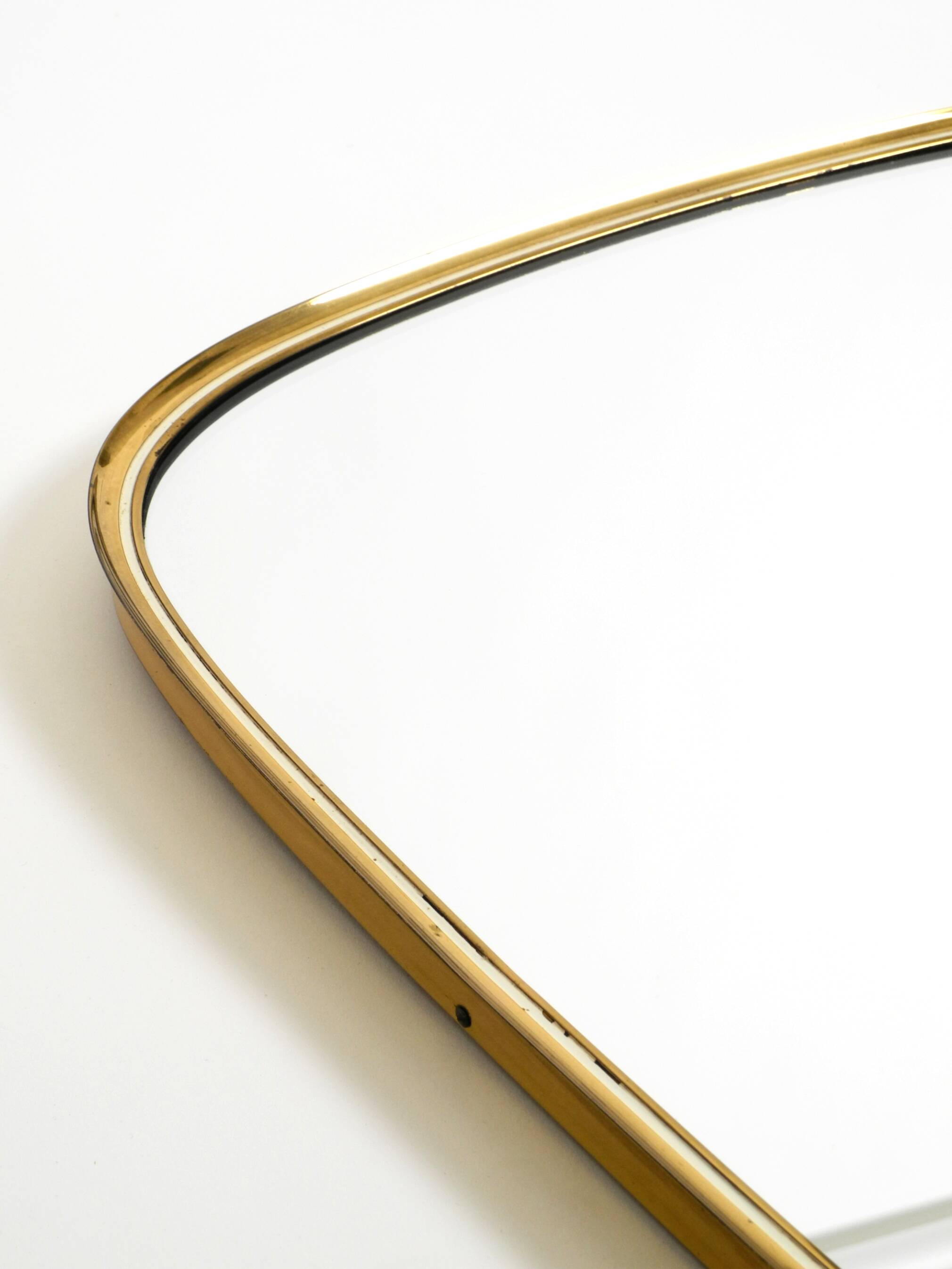 Heavy mid-century brass kidney-shaped wall mirror from Münchner Zierspiegel