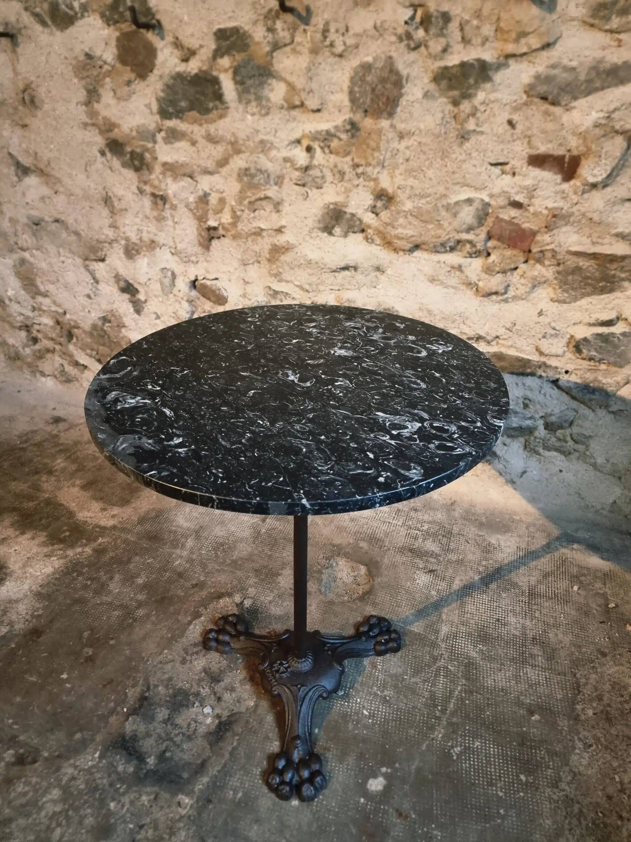 Old French bistro table with a marble top and a cast iron base.
