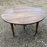 Table ronde en noyer de 130 cm de diamètre .