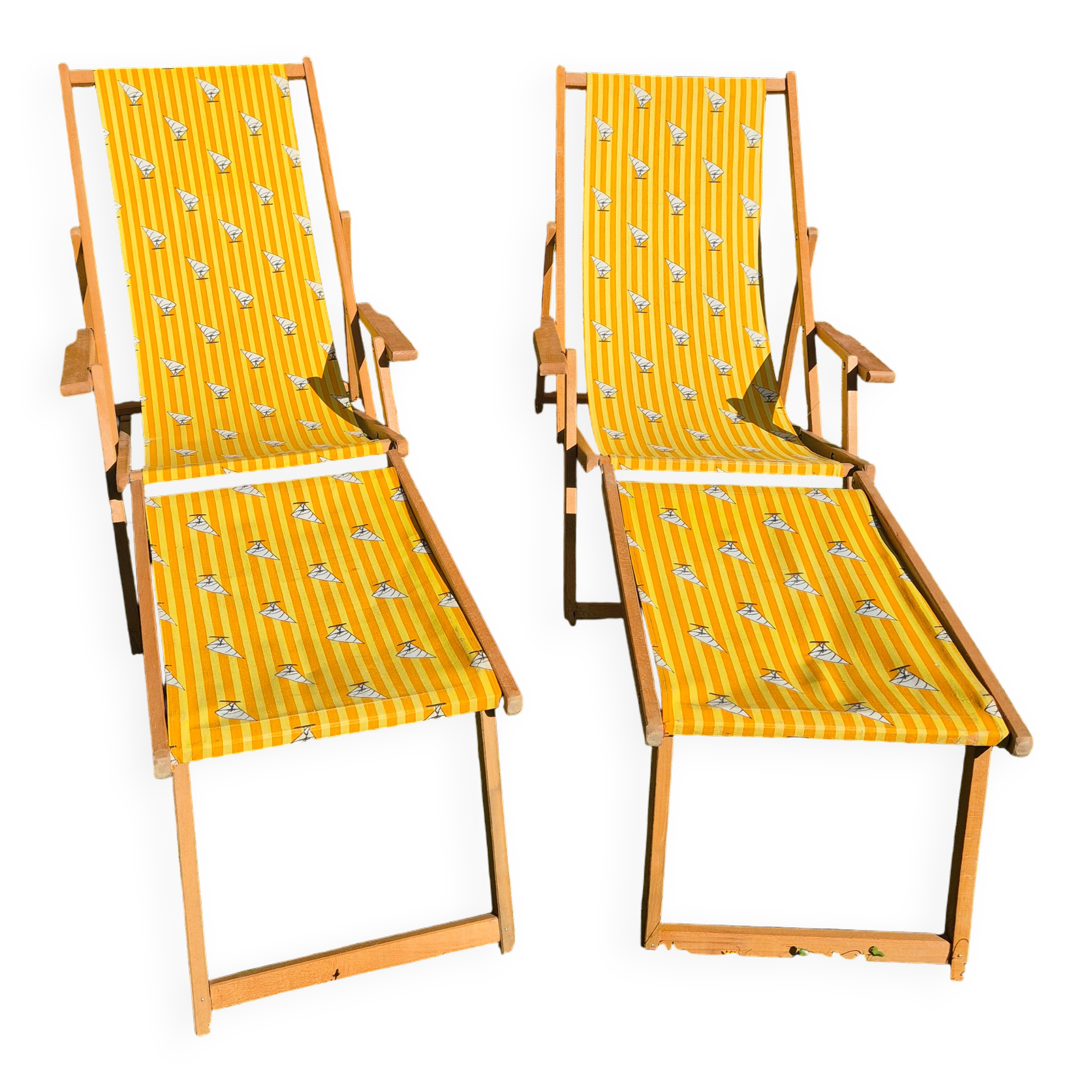 2 vintage Chilean deck chairs made of wood and yellow fabric printed with sailboats, with footrests.