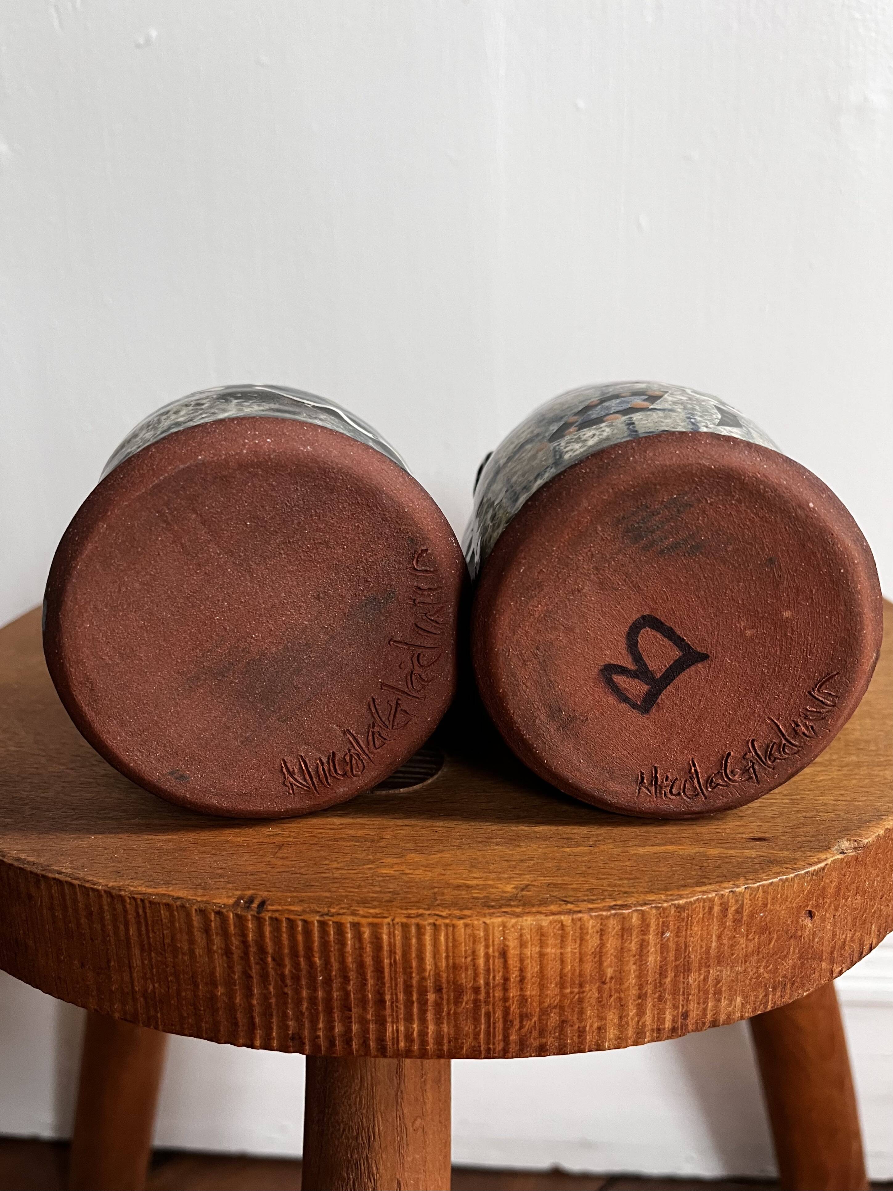 Vintage terracotta mugs with glazed designs and flower/fish motifs