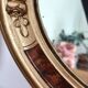 Antique medallion mirror with a gilded and relief-carved frame.