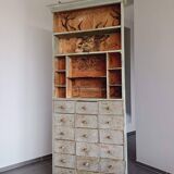 Craft cabinet with drawers with a very old tobacco advertisement in the background