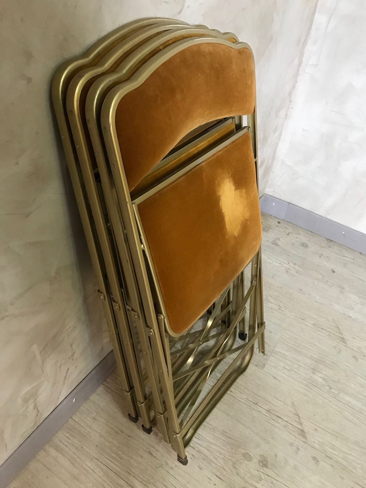 Four folding velvet and brass chairs