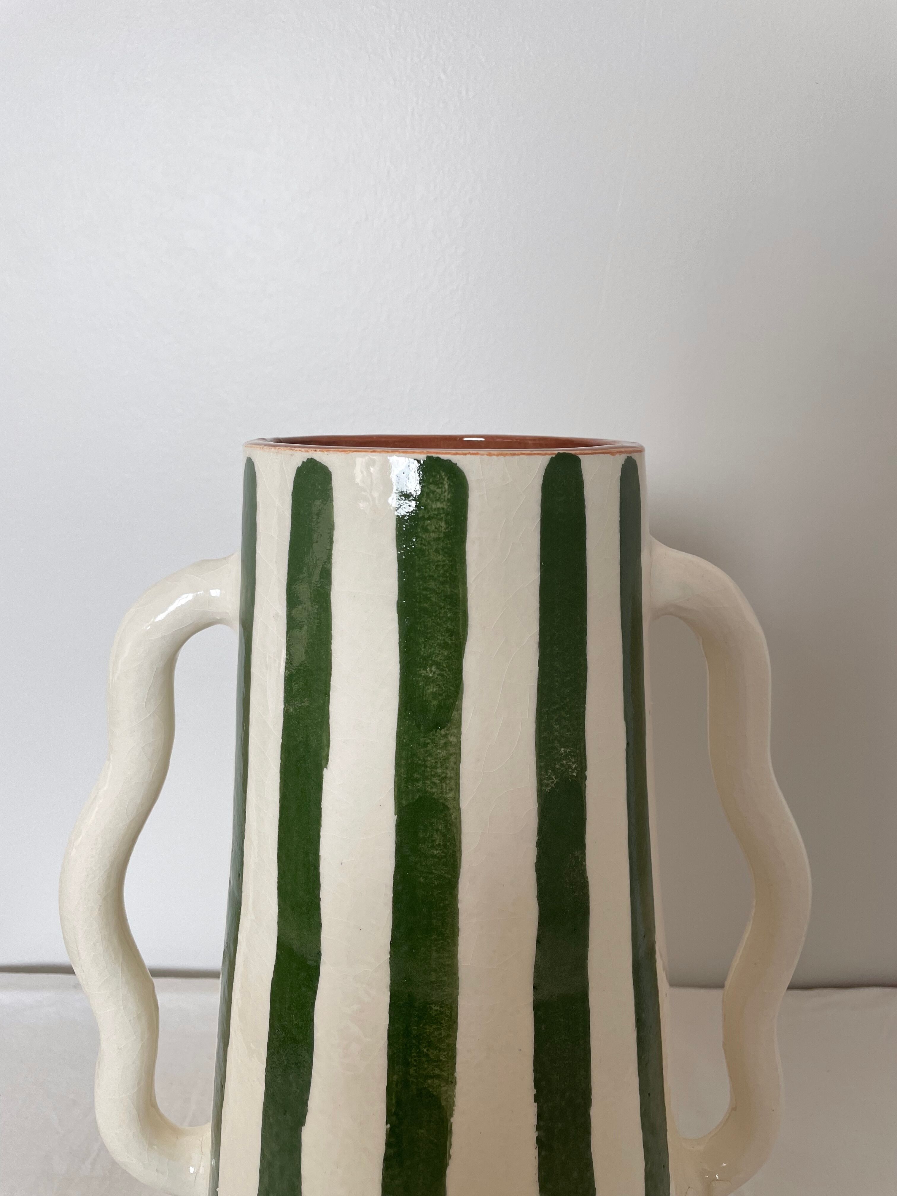 Handmade green and white striped ceramic vase with abstract corrugated handheld
