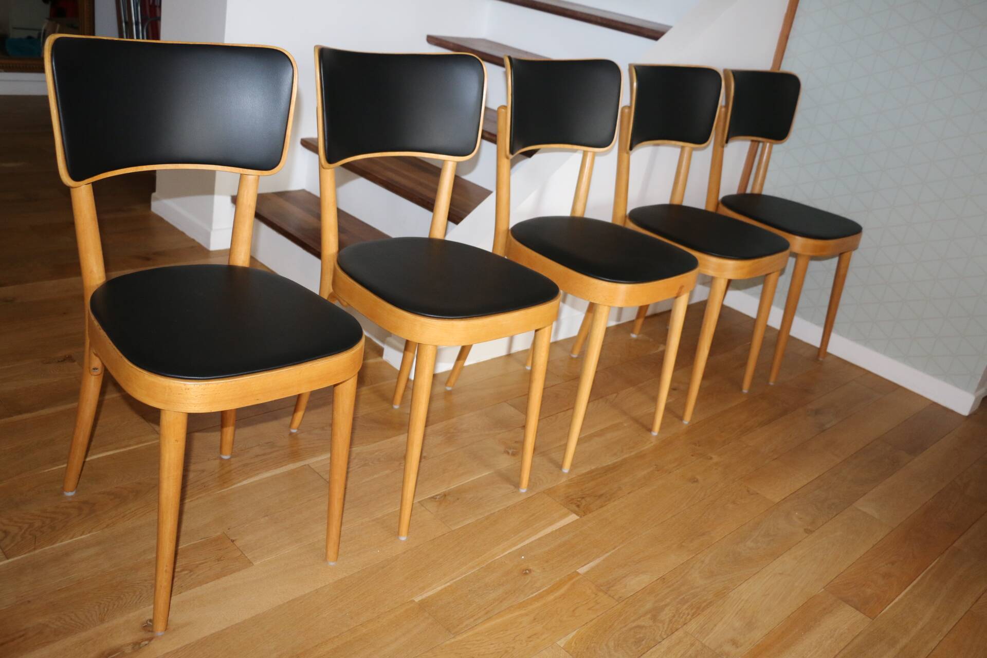 5 baumann chairs with large backs in black faux leather.