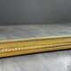 Large antique gilded wooden mirror in Louis XVI style with a sculpted pediment, 19th century.
