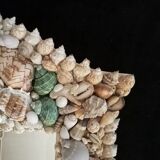 Miroir biseauté, recouvert d'une accumulation de coquillages de collection et de branches de corail