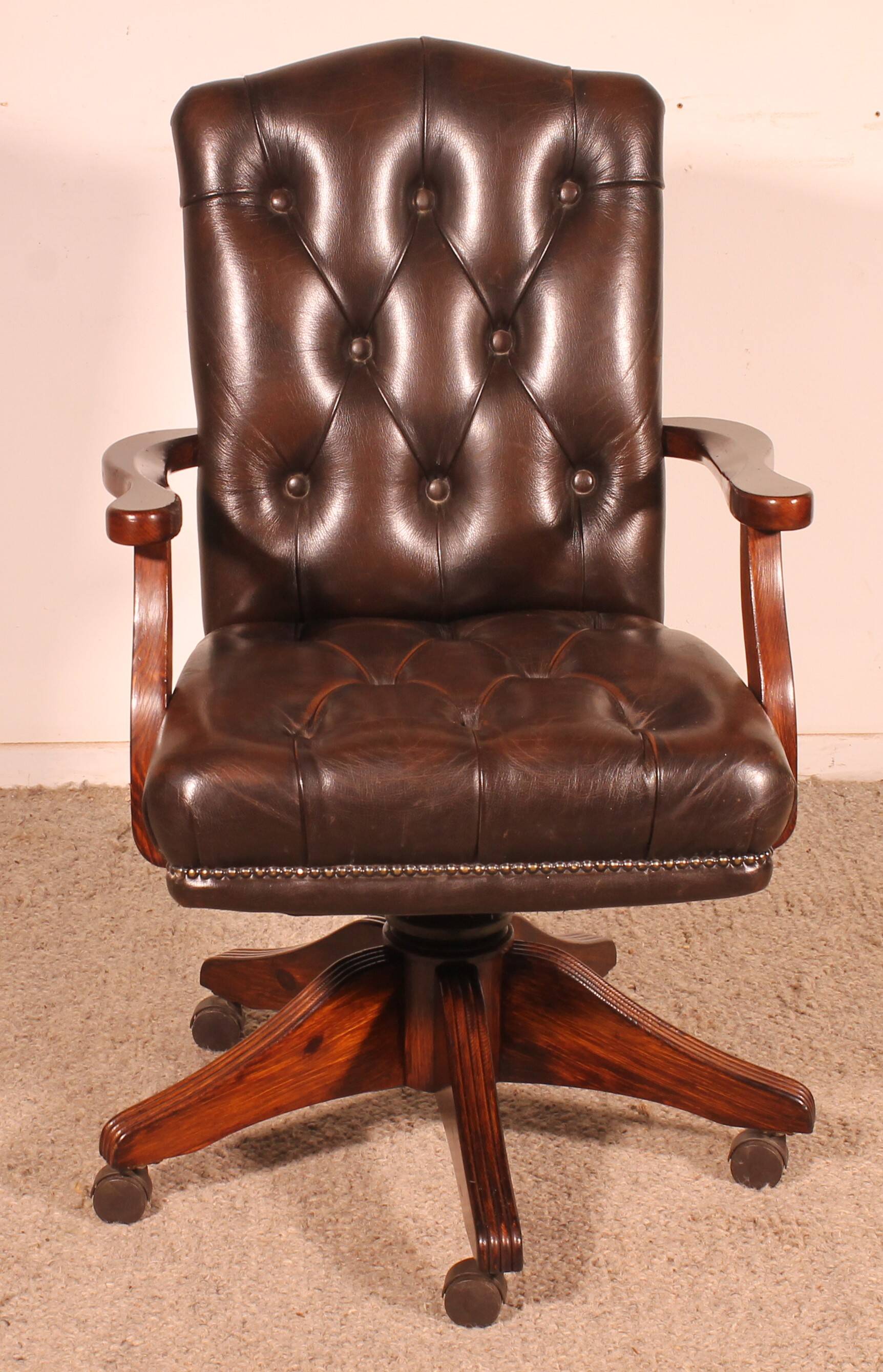 Office chair known as a director's chair in wood and tufted leather.