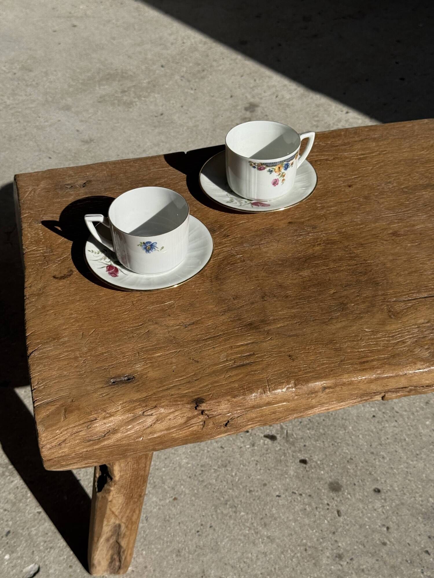 Pair of white porcelain cups from ADP France with a floral pattern and their s