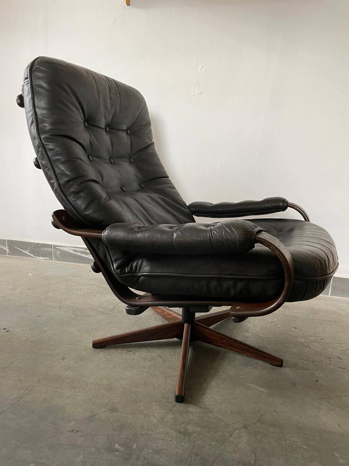 Scandinavian swivel lounge chair in black leather with a bent wood frame, 1970s.