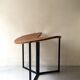 Modernist round folding dining table in wood and metal.