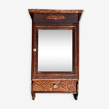 Old carved wooden medicine cabinet with beveled mirror