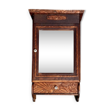 Old carved wooden medicine cabinet with beveled mirror