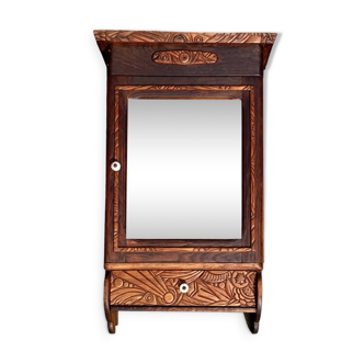 Old carved wooden medicine cabinet with beveled mirror