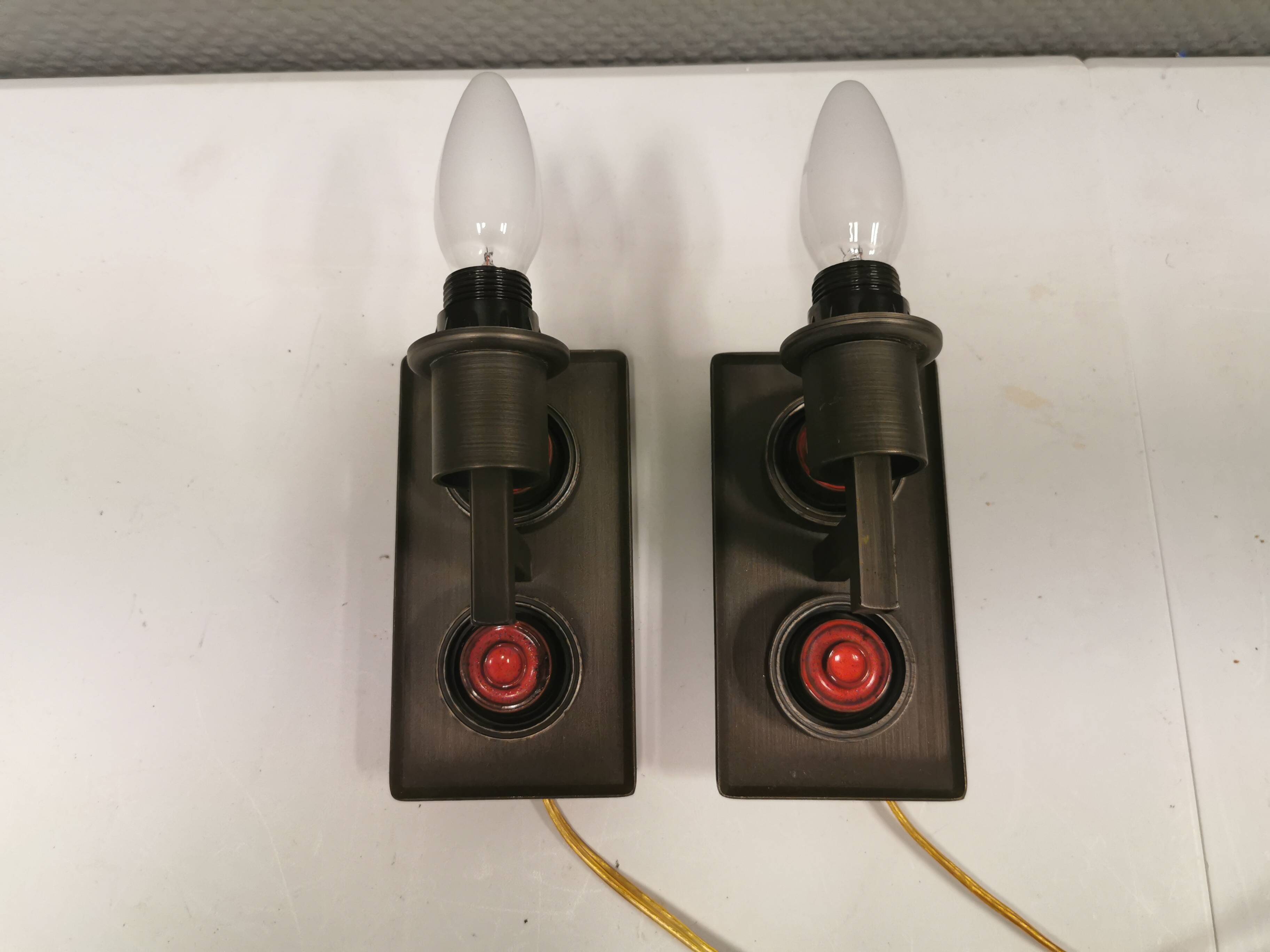 A set of Vitrika Denmark, cast iron wall lights with red details.