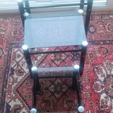 3 nesting tables in black metal with smoked glass tops.