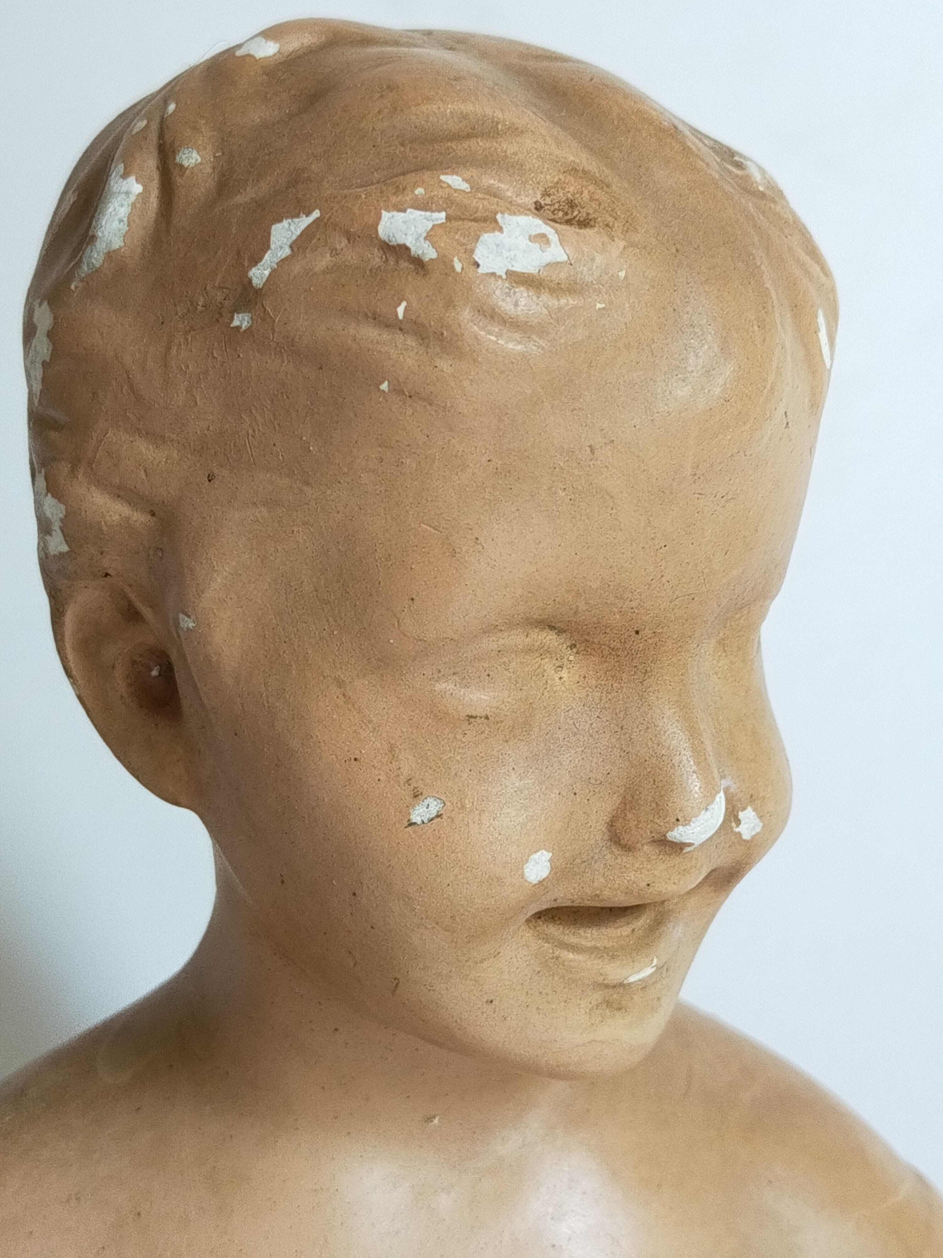 Bust of a small child in ancient plaster