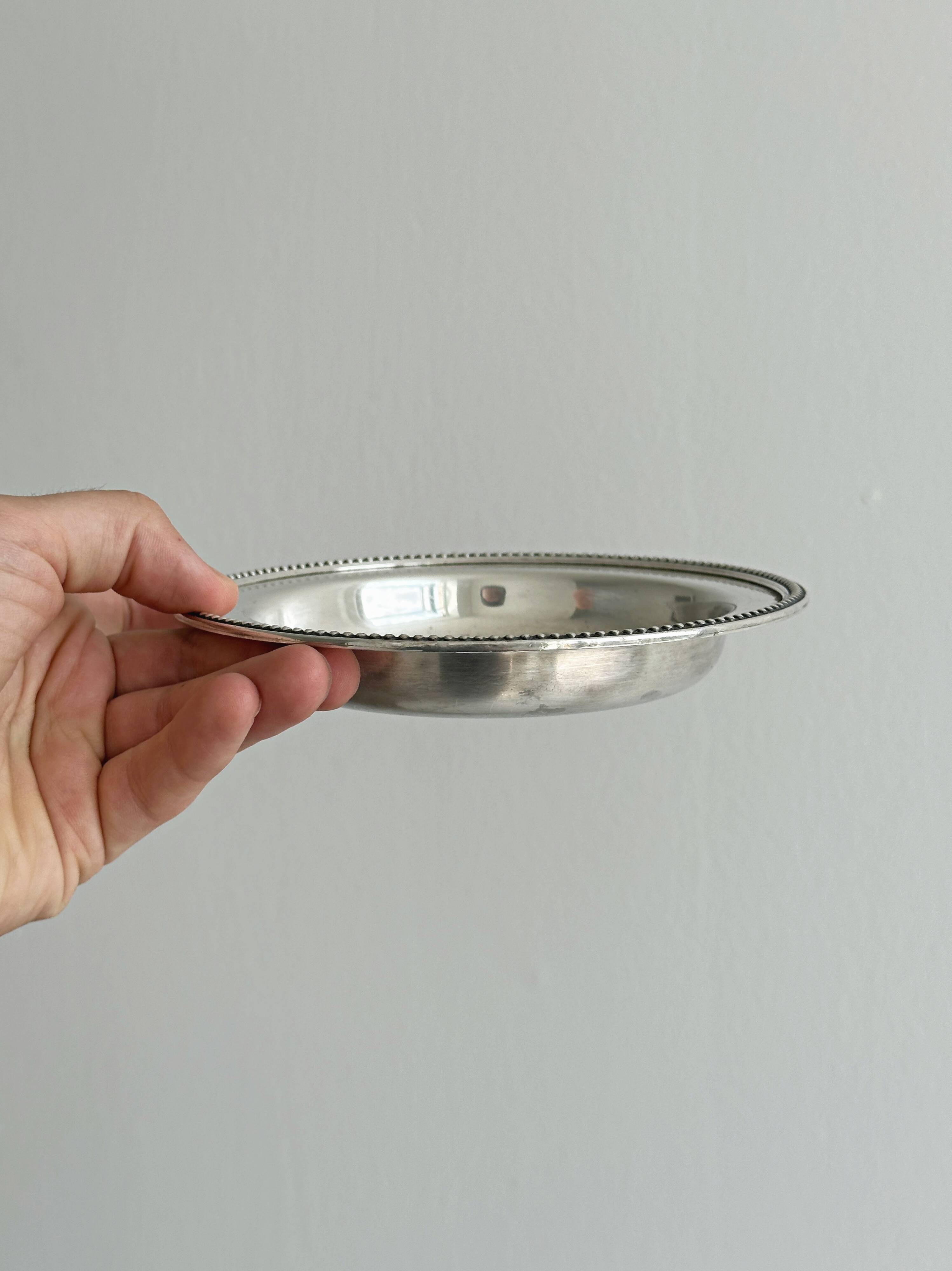 Round patinated silver-plated metal dish
