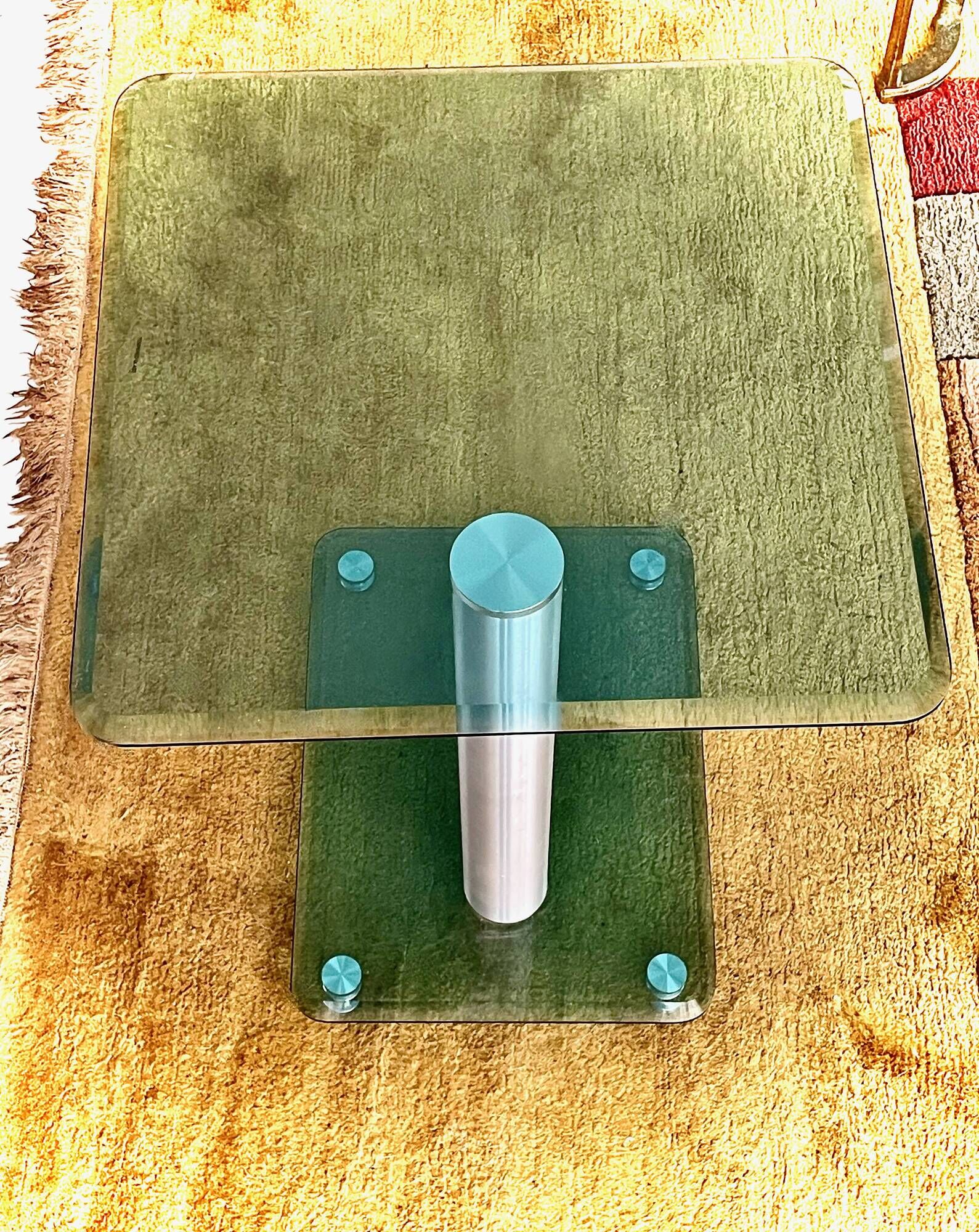 Contemporary square side table in glass with a metallic central column.