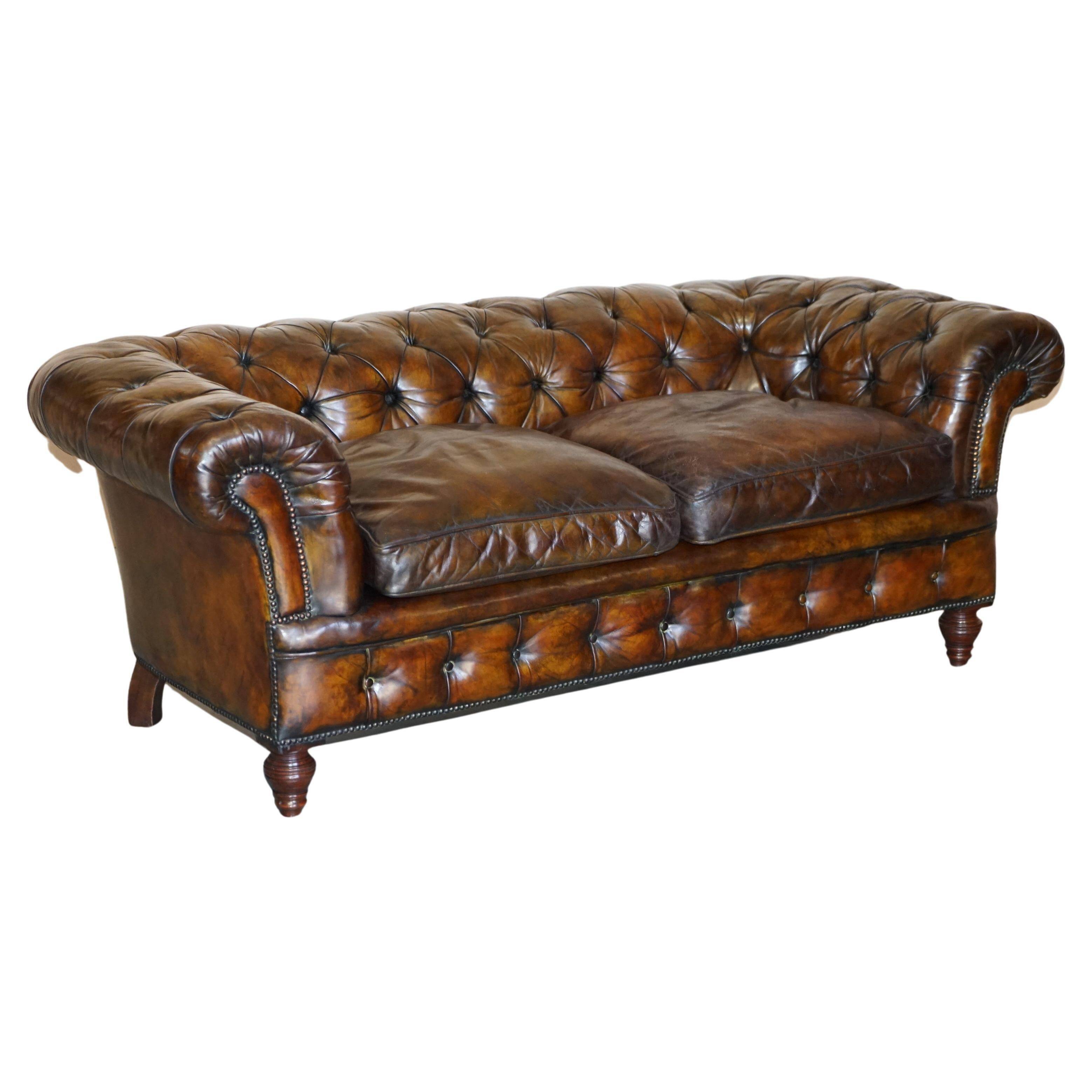 Victorian Chesterfield leather upholstered canapé with feather cushions.