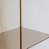 Free-standing shelf in gilded brass with smoked glass shelves. 1970s.