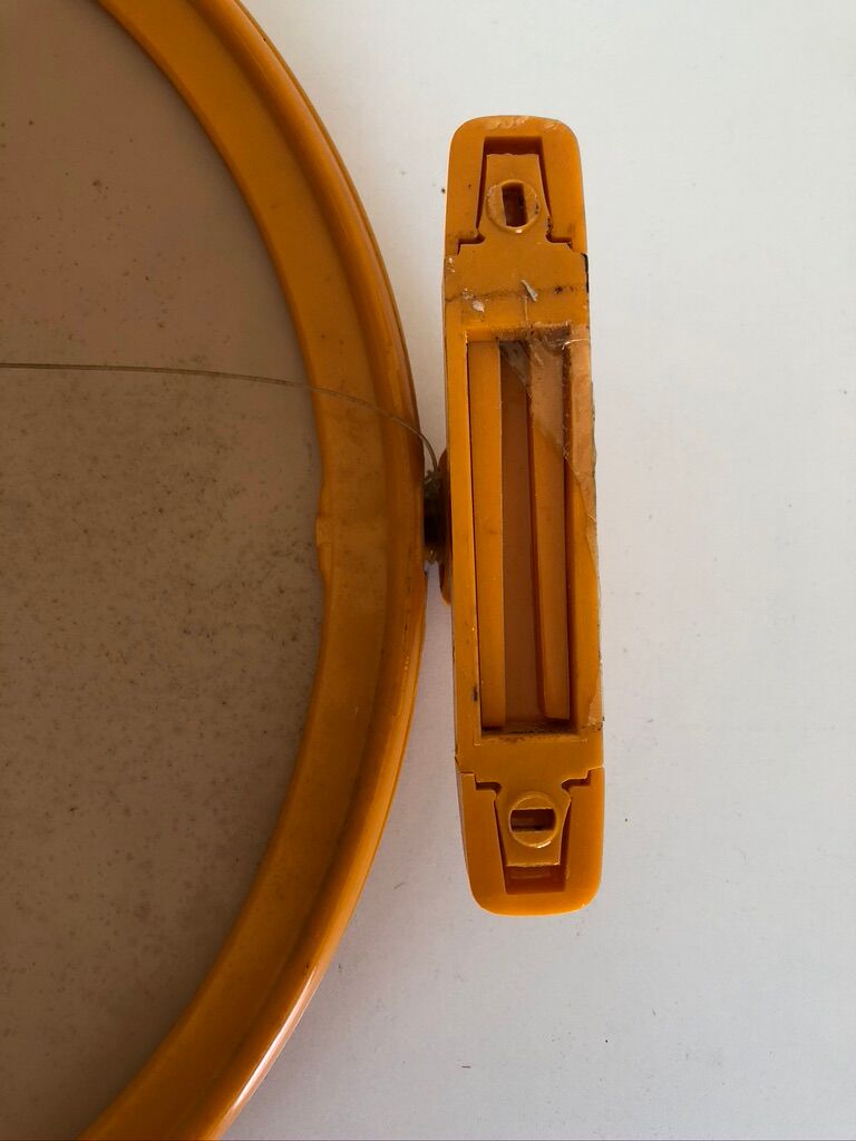 Tiltable orange plastic mirror with matching wall light