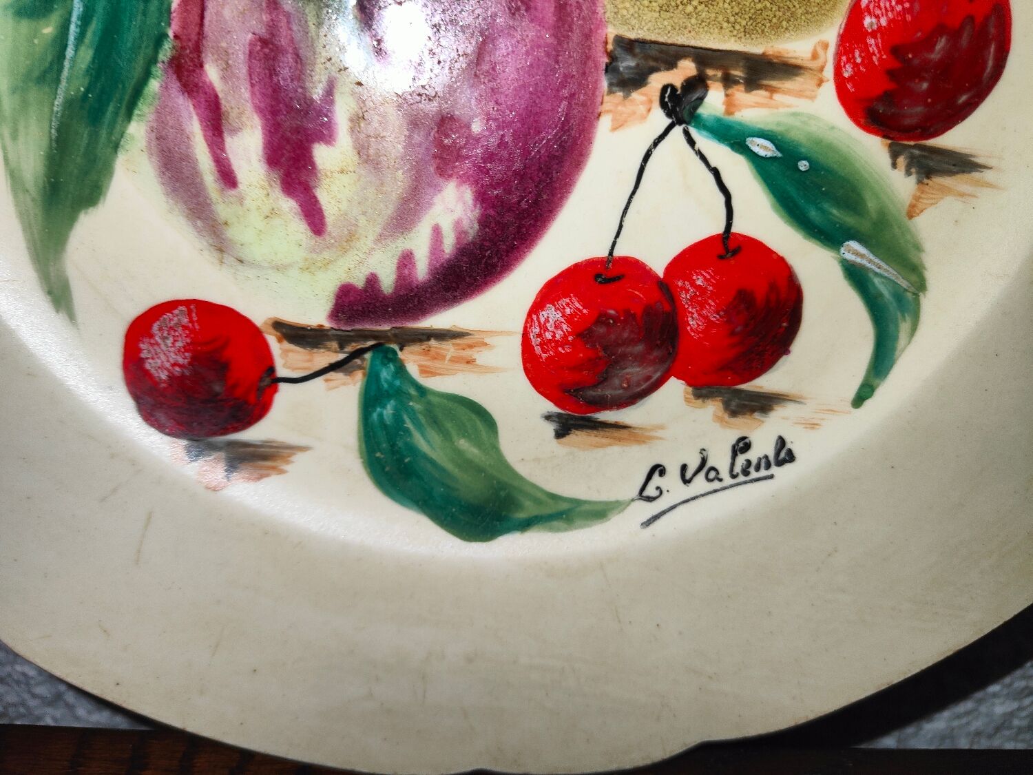 Faience plate in Longwy enamels signed Léa Valenti representing Fruits