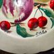 Faience plate in Longwy enamels signed Léa Valenti representing Fruits
