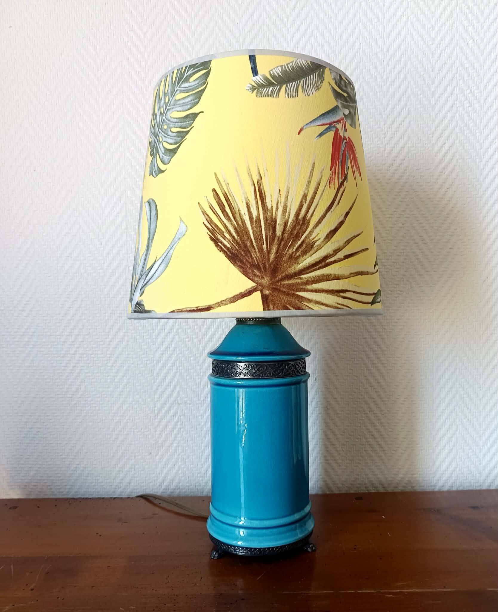 Blue ceramic lamp with claw feet and foliage lampshade.