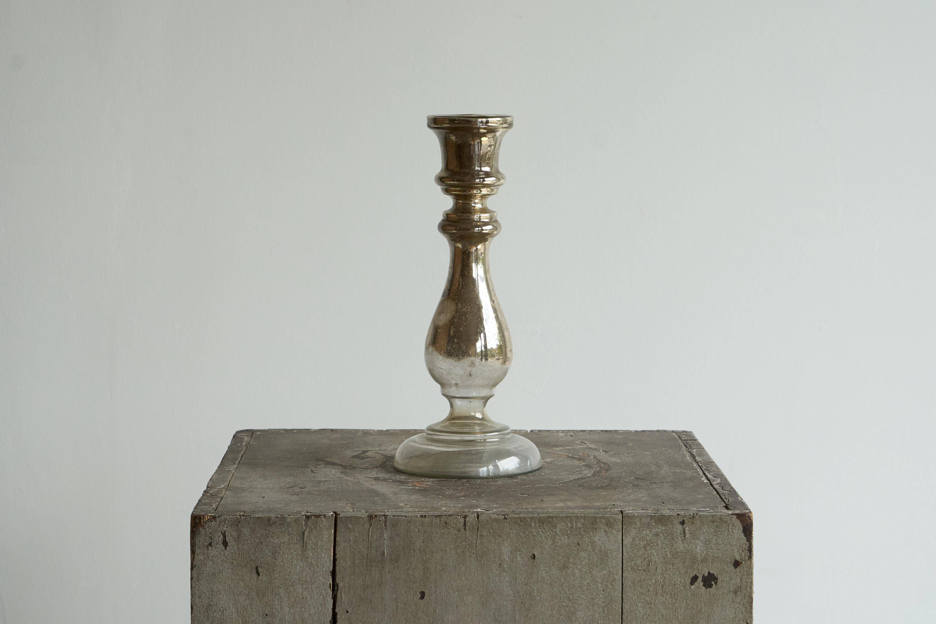 Antique mercury glass candlestick with a patina and silver finish.
