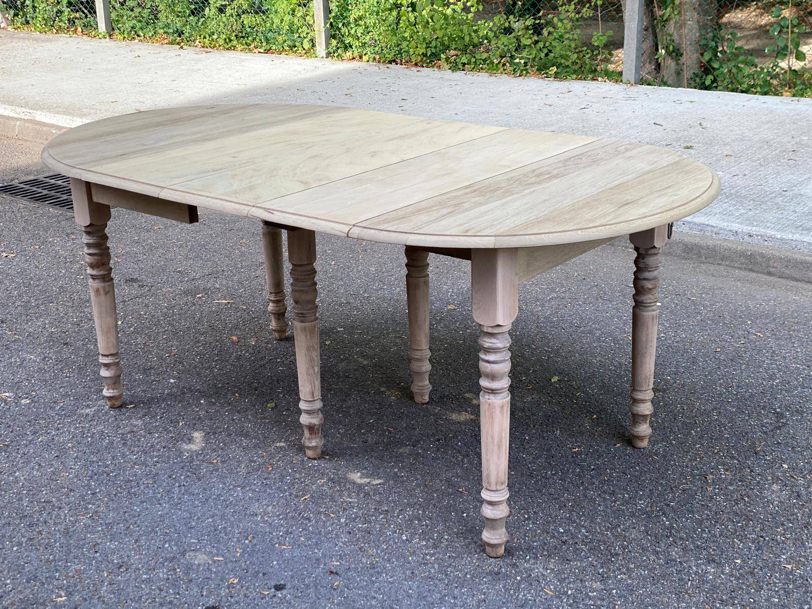 Round extendable dining table with flaps, stripped in raw oak, with 3 extensions.