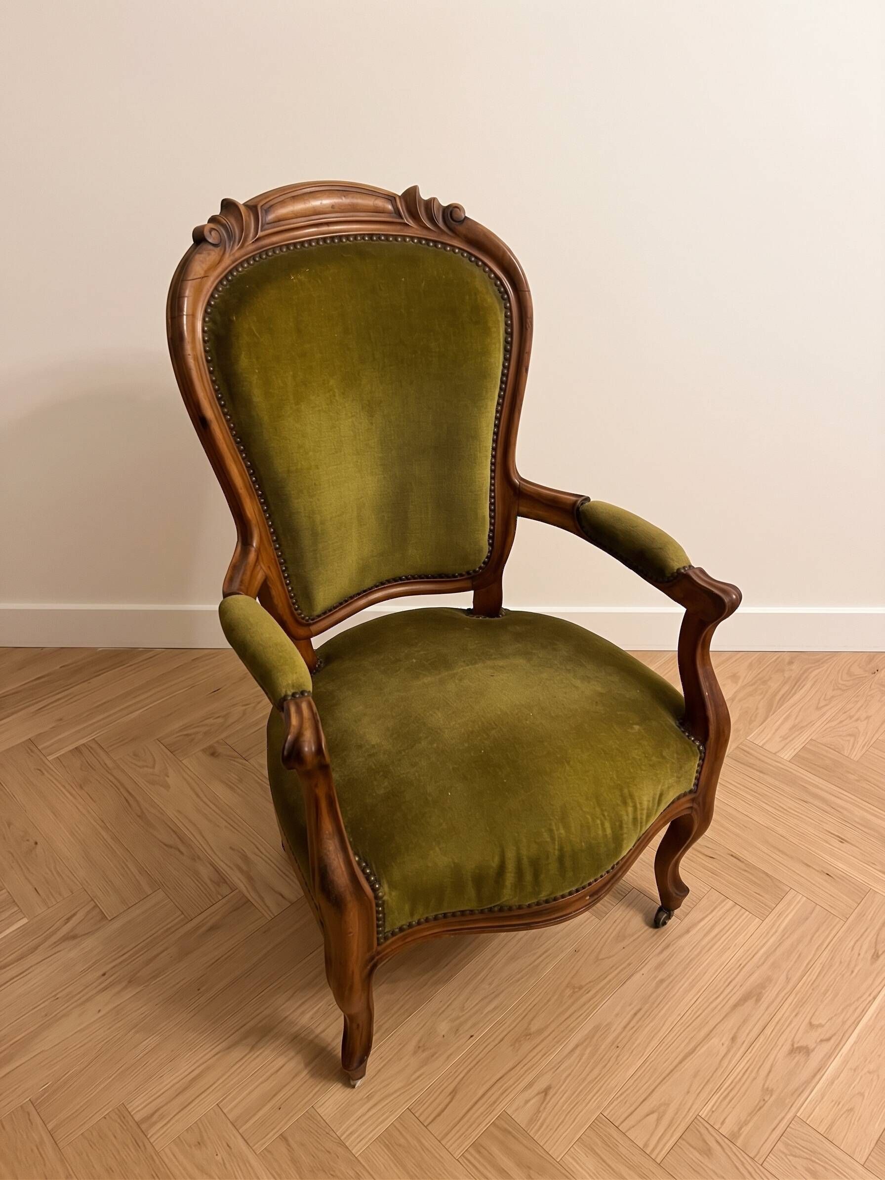 Antique armchair in olive green velvet and carved wood.