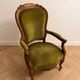 Antique armchair in olive green velvet and carved wood.