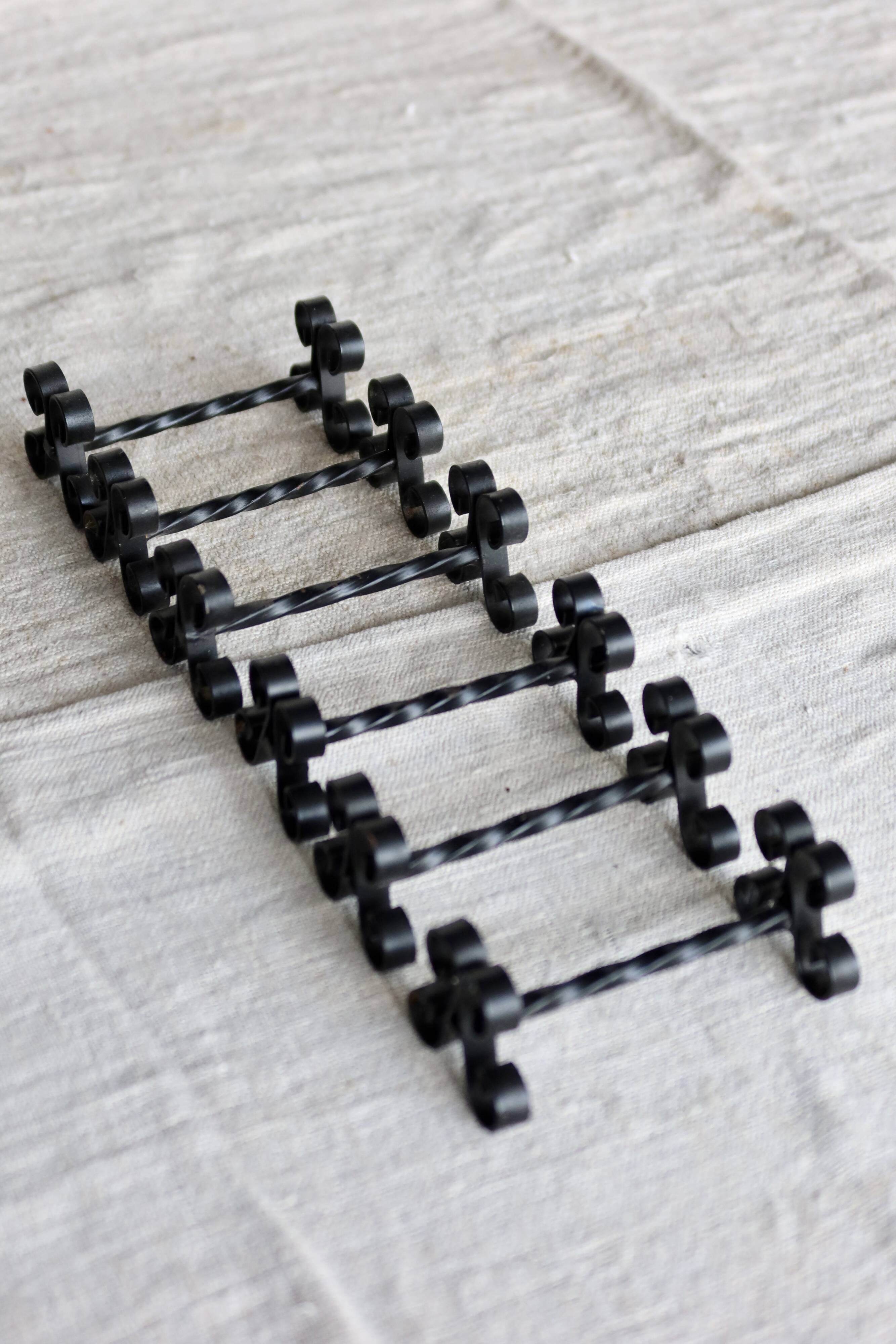 6 vintage black metal knife rests with scrollwork decoration