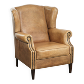 Fauteuil à oreilles en cuir de vache confortable avec un look anglais intemporel.