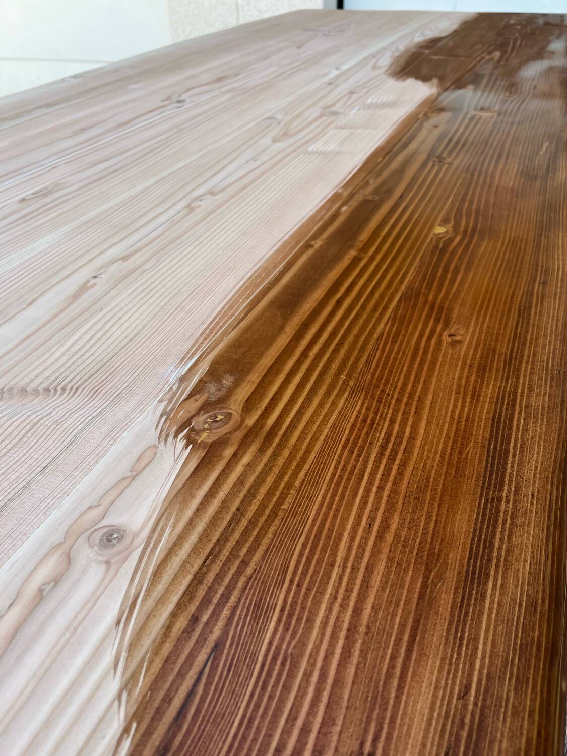 Bistro table with a raw wood top and a central cast iron base.