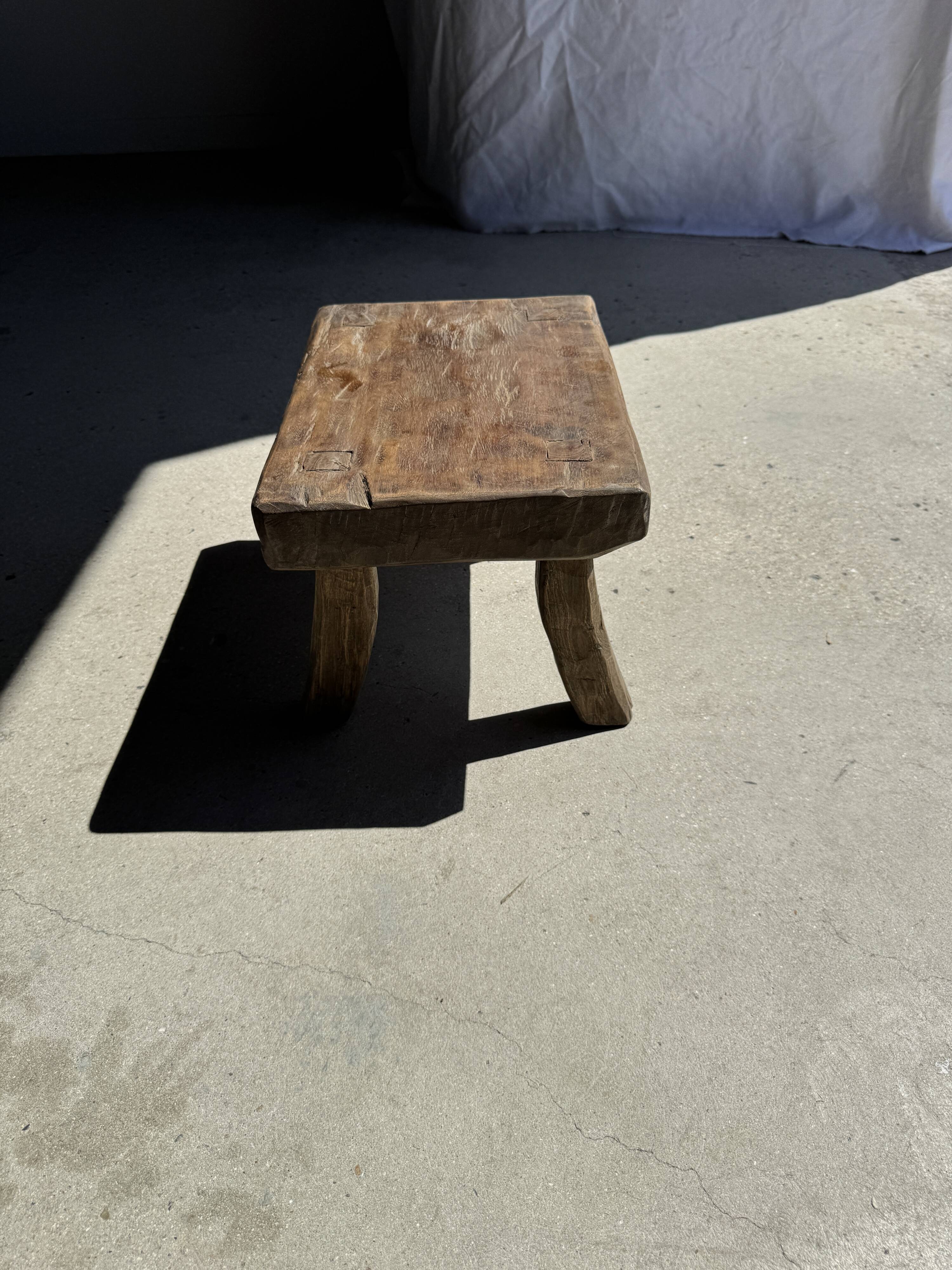 Small stool, rectangular solid teak side table with curved legs.