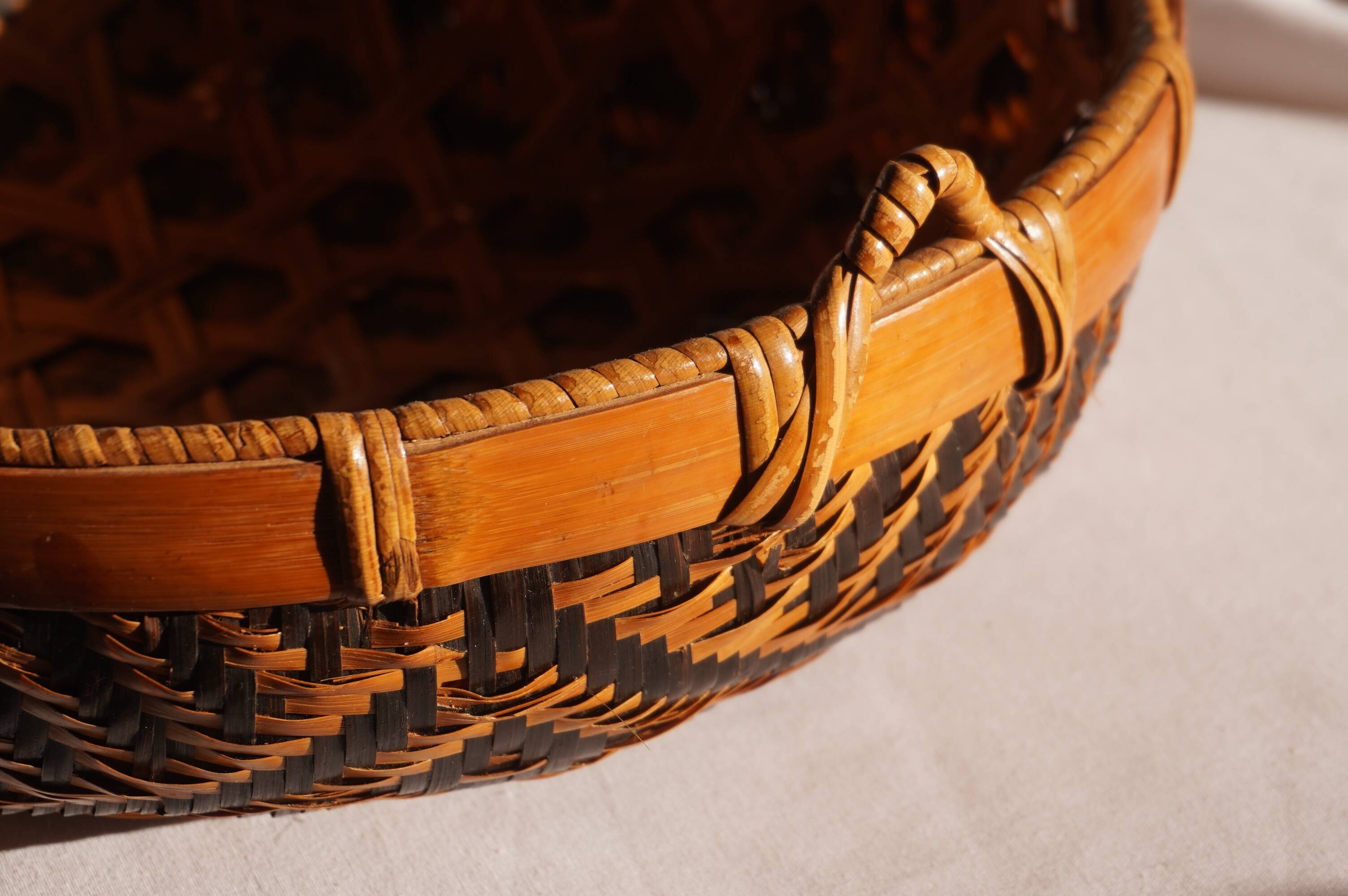 Woven patterned basket, made of straw and bamboo.