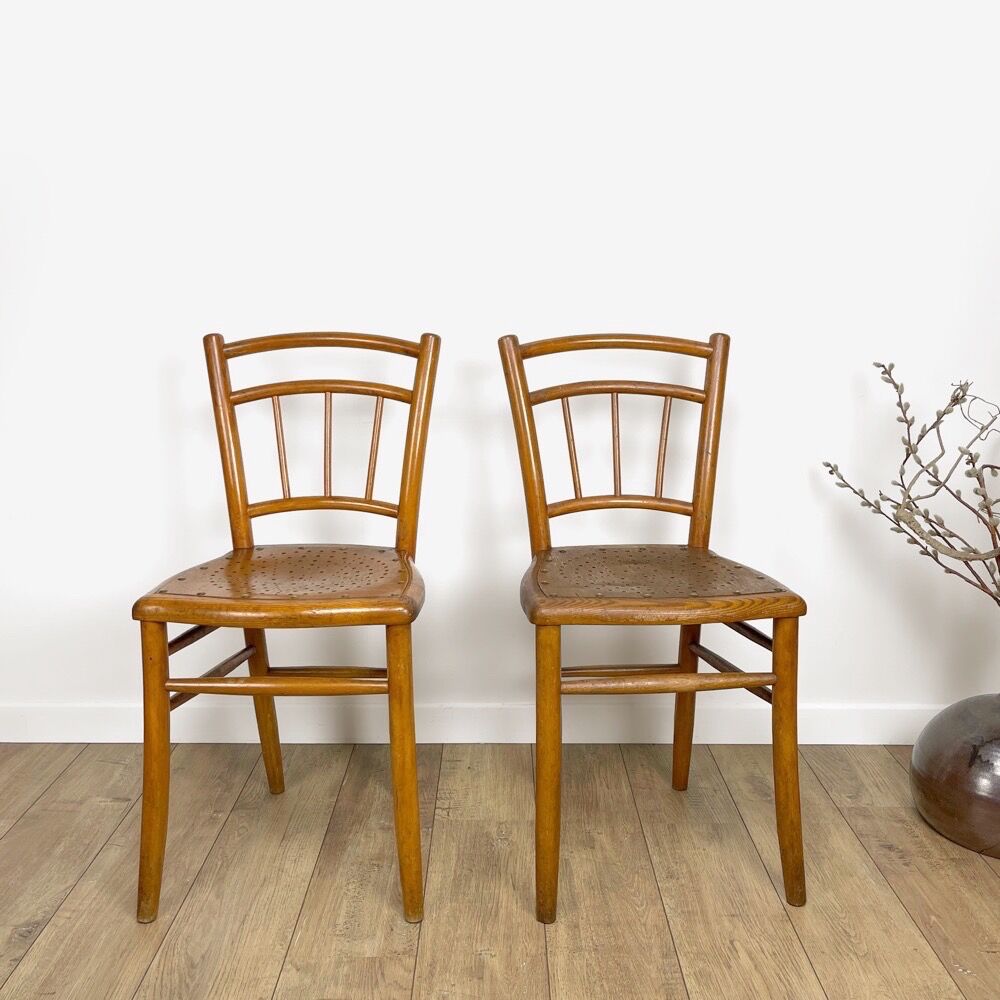 Pair of curved wood bistro chairs and studded and perforated seat