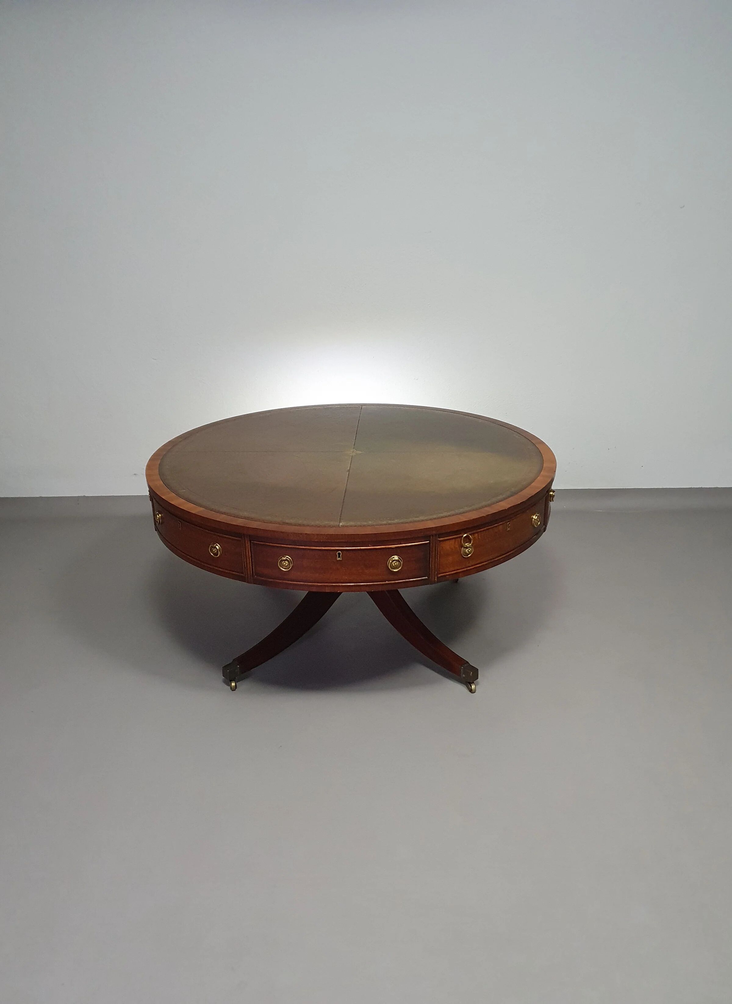 Table basse / table tambour victorienne « Heldense » en acajou avec plateau en cuir sur roulettes en laiton. Années 1980