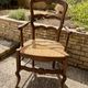 Antique Provençal armchair in wood with a straw seat.