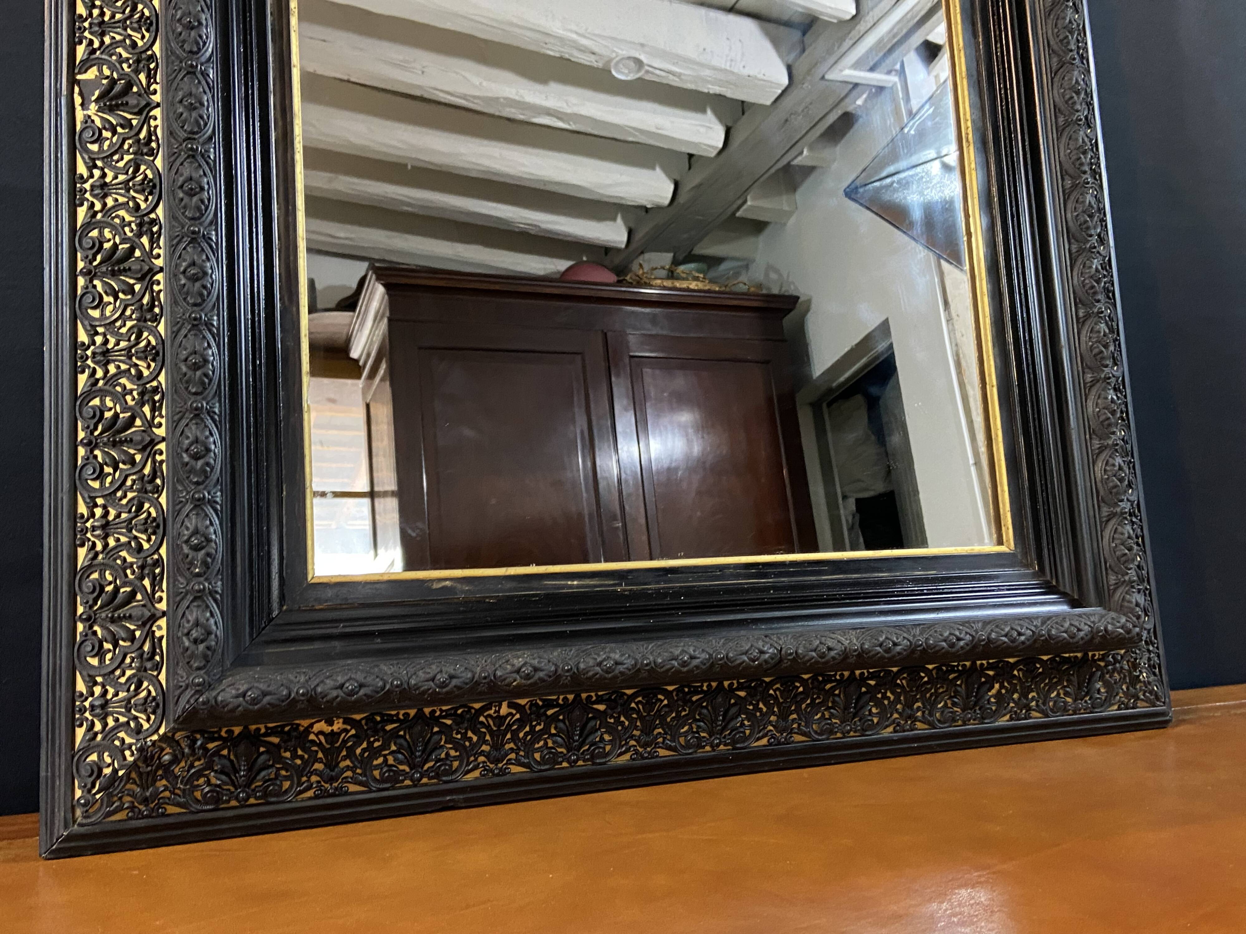 19th-century mirror Napoleon III in blackened wood on a gold background.