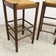 Pair of 80 cm high straw and beech bar stools