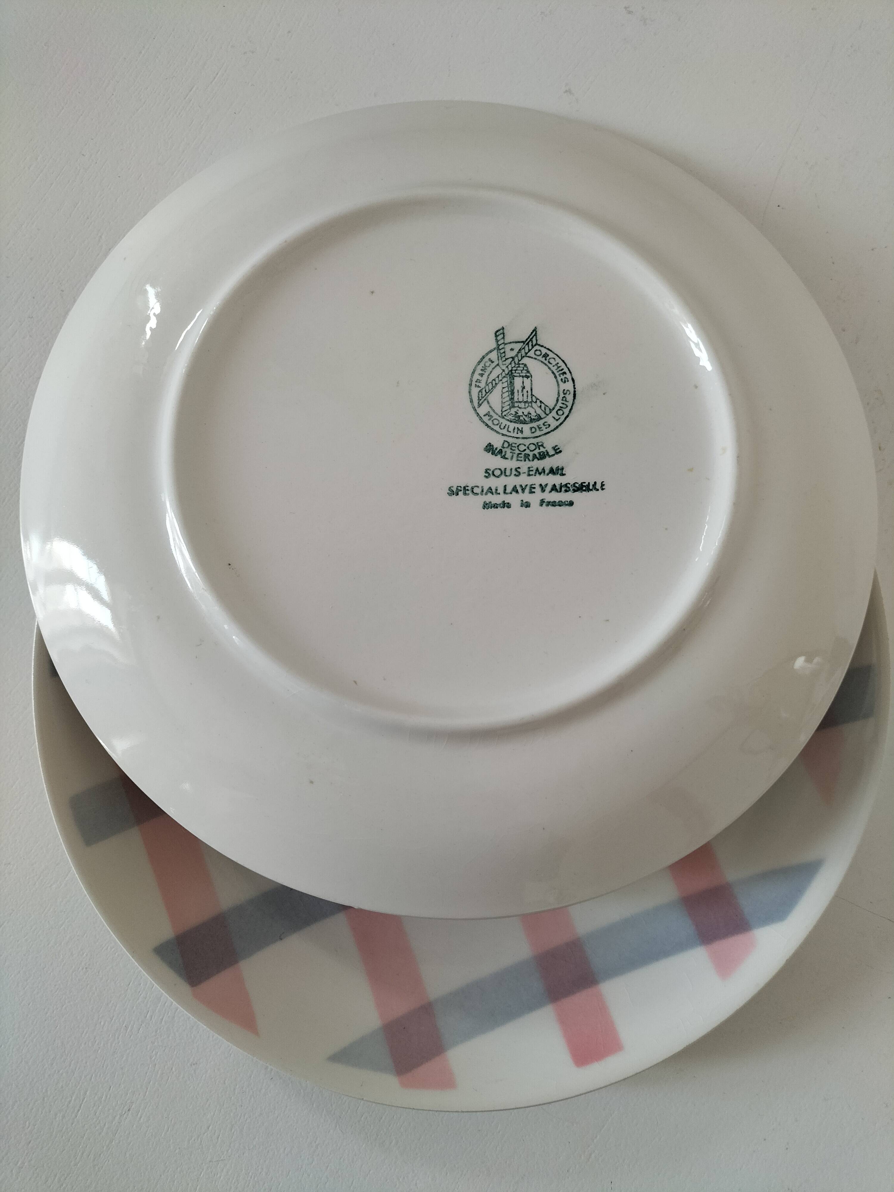 Two dessert plates Moulin des Loups with a pink and grey tablecloth design.