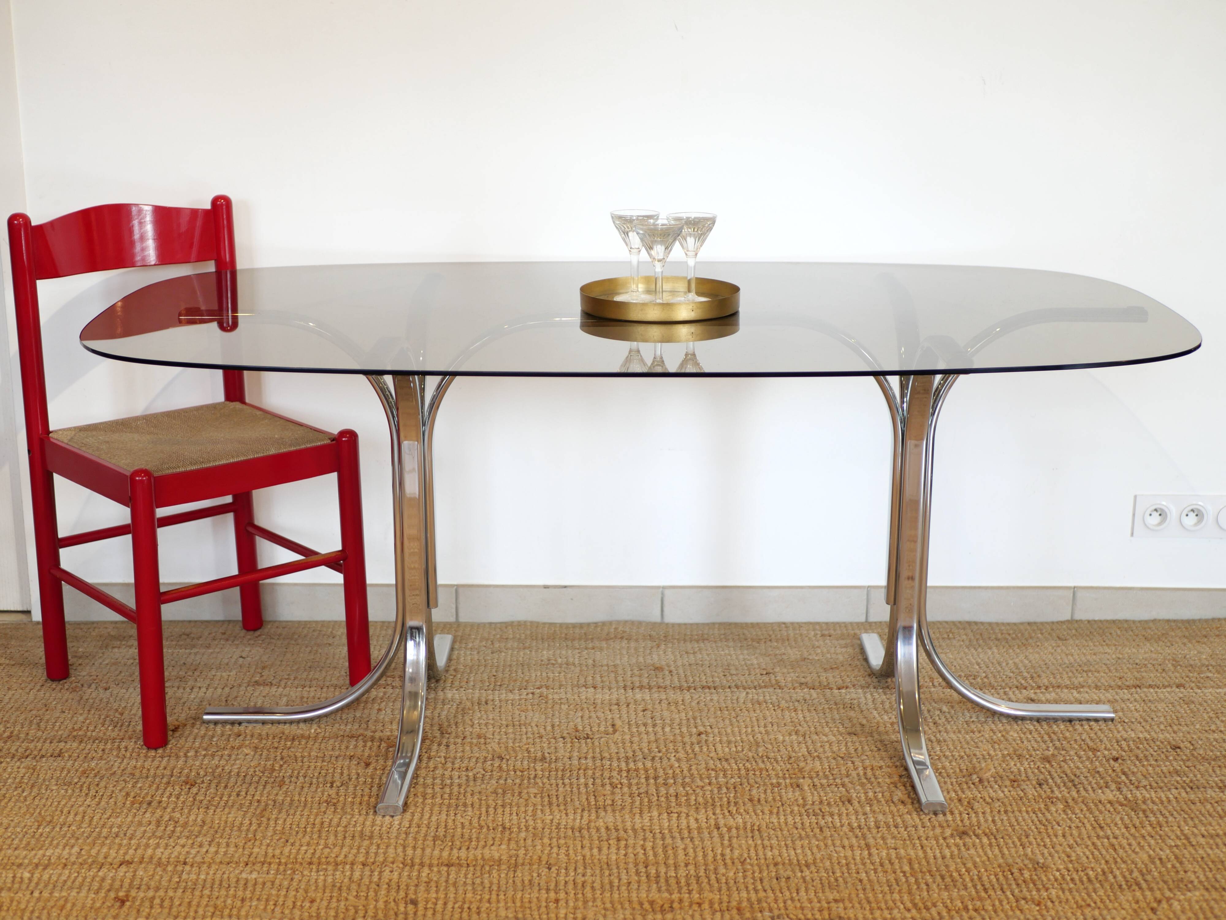 Dining table with smoked glass top and chrome base.
