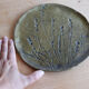 Decorative wall plaque in brass with a floral design.