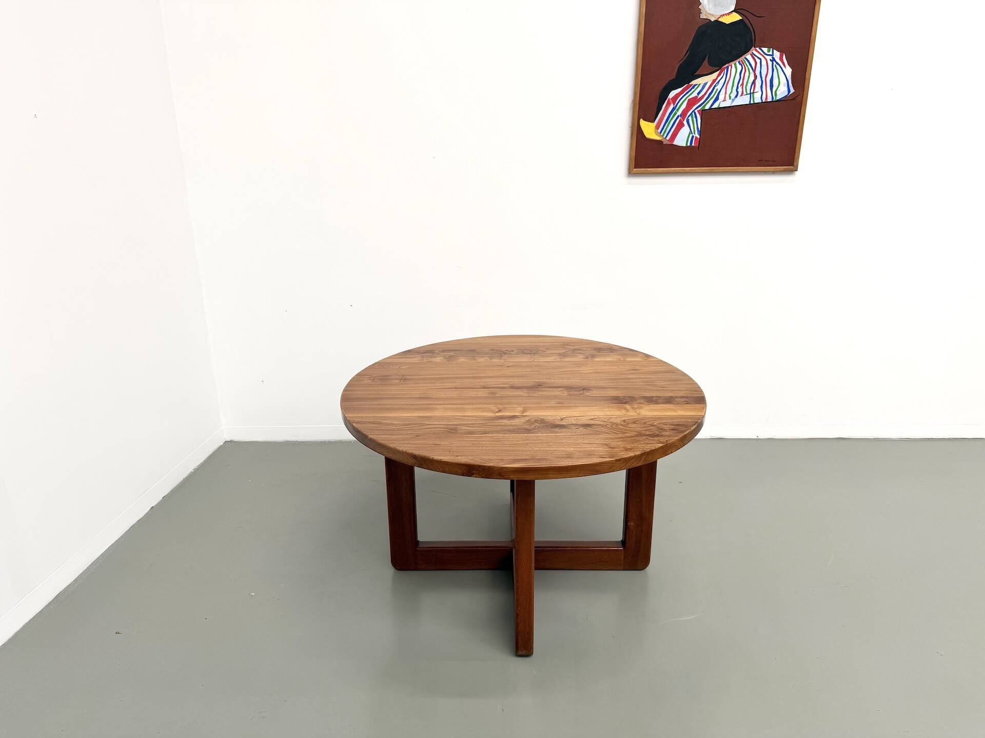 Modernist round table in solid elm, crossed legs.